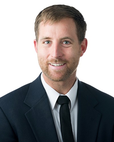 A headshot of a man wearing a suit.